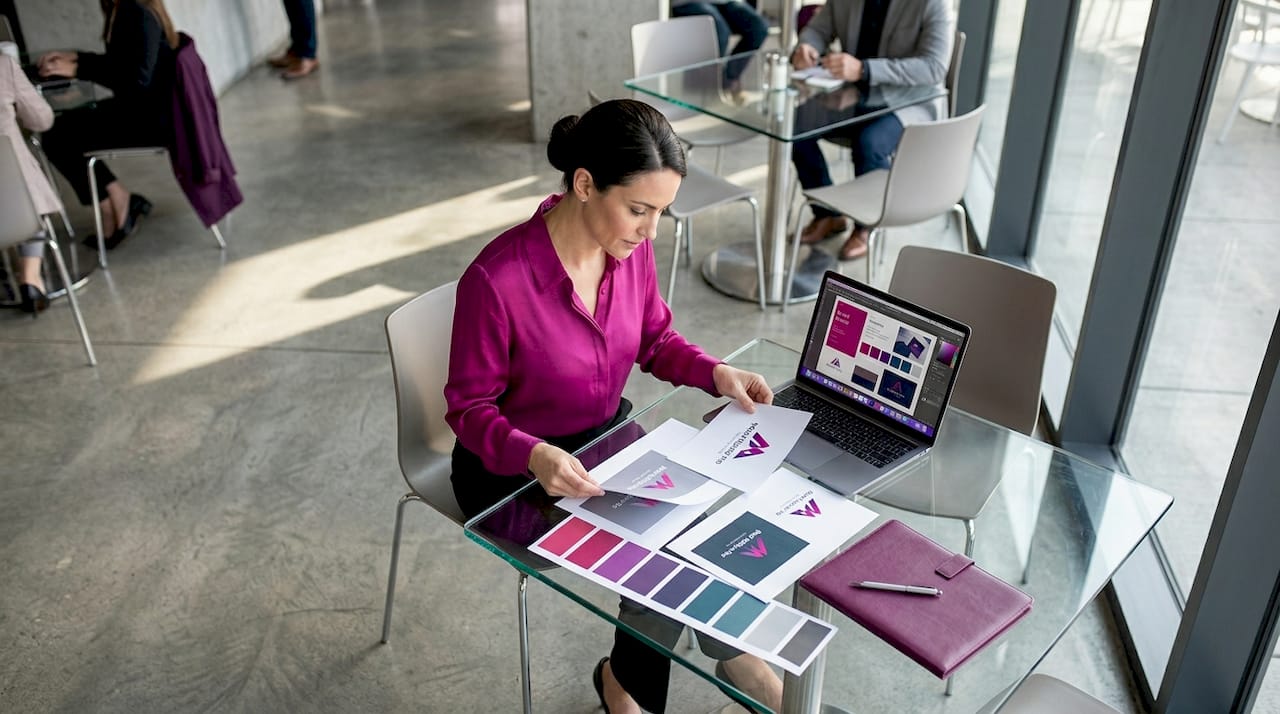 Business owner reviewing printed logo concepts